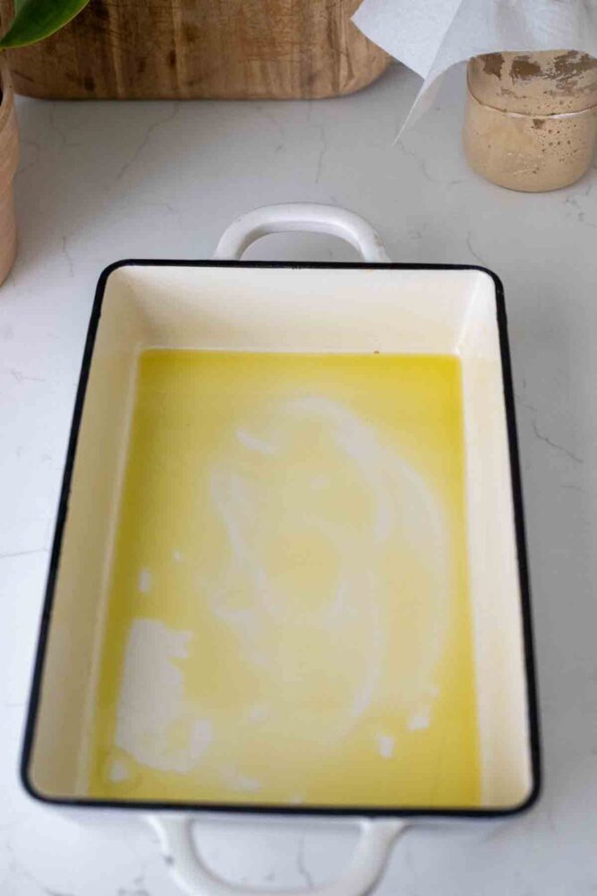 Olive oil at the bottom of a cast iron baking dish.
