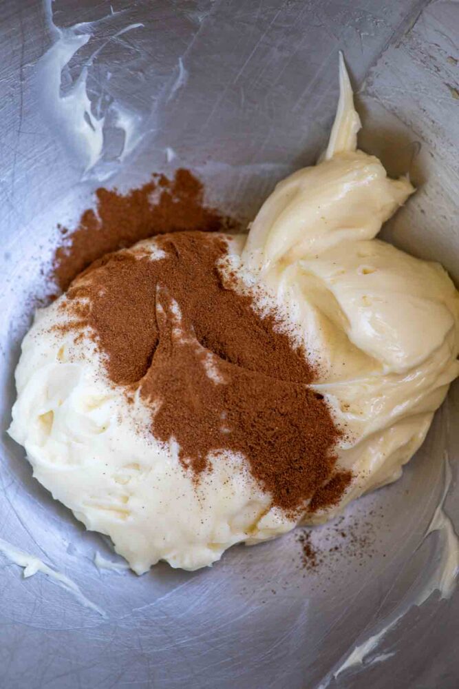 Whipped honey butter with cinnamon sprinkled on top in a stand mixer bowl.