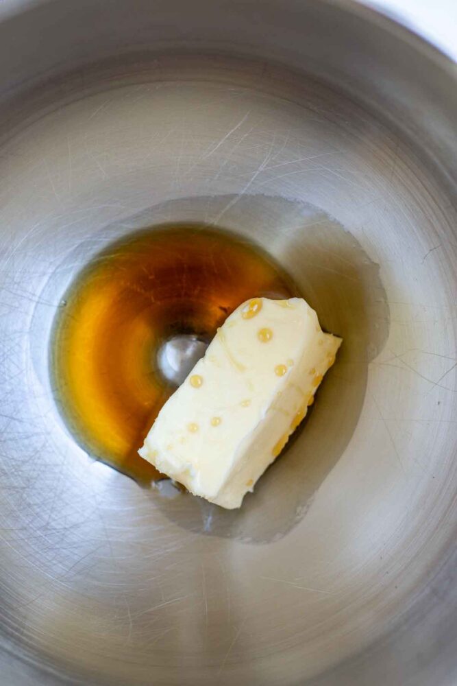 Maple syrup and softened butter in a metal bowl.