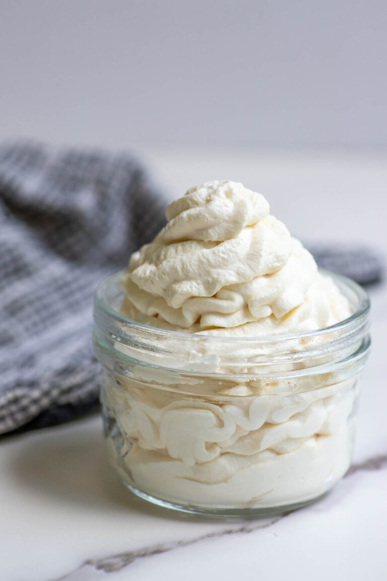 Whipped cream in a jar with a towel in the background.
