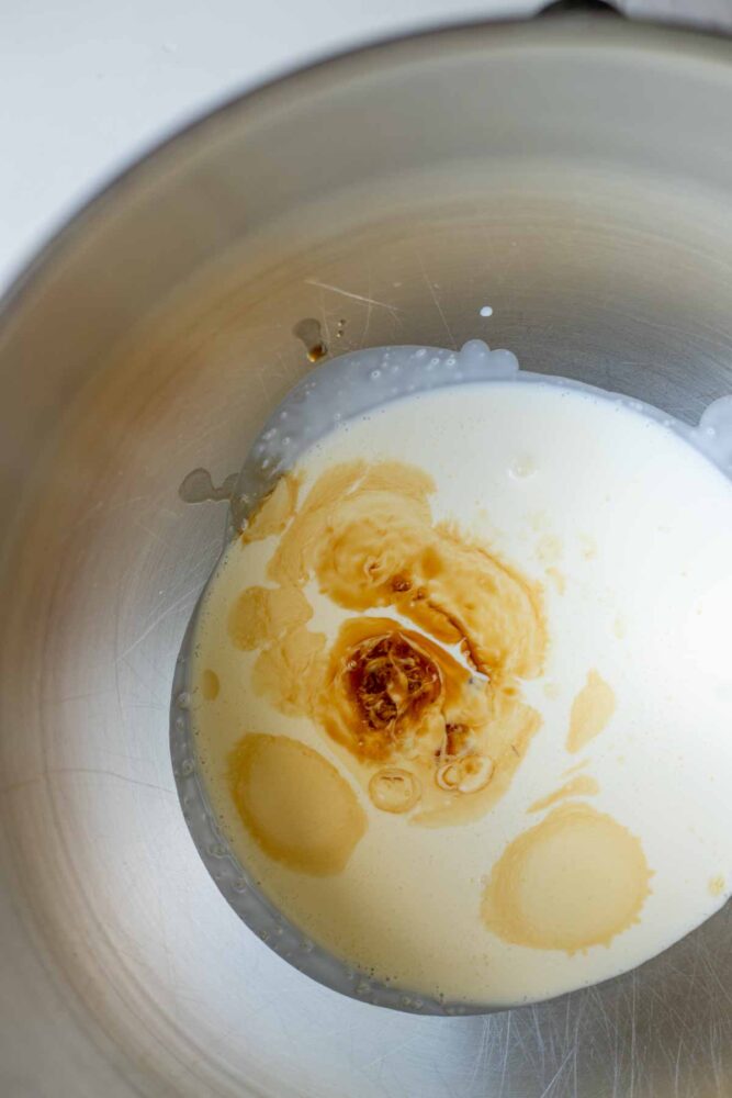 Whipping cream, vanilla, and maple syrup in a stand mixer bowl.