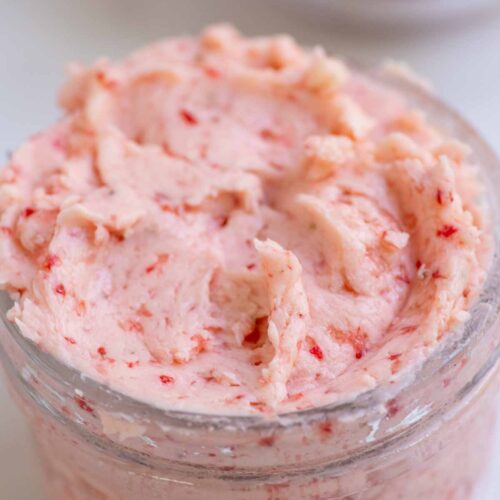 Close up picture of strawberry butter in a glass jar.