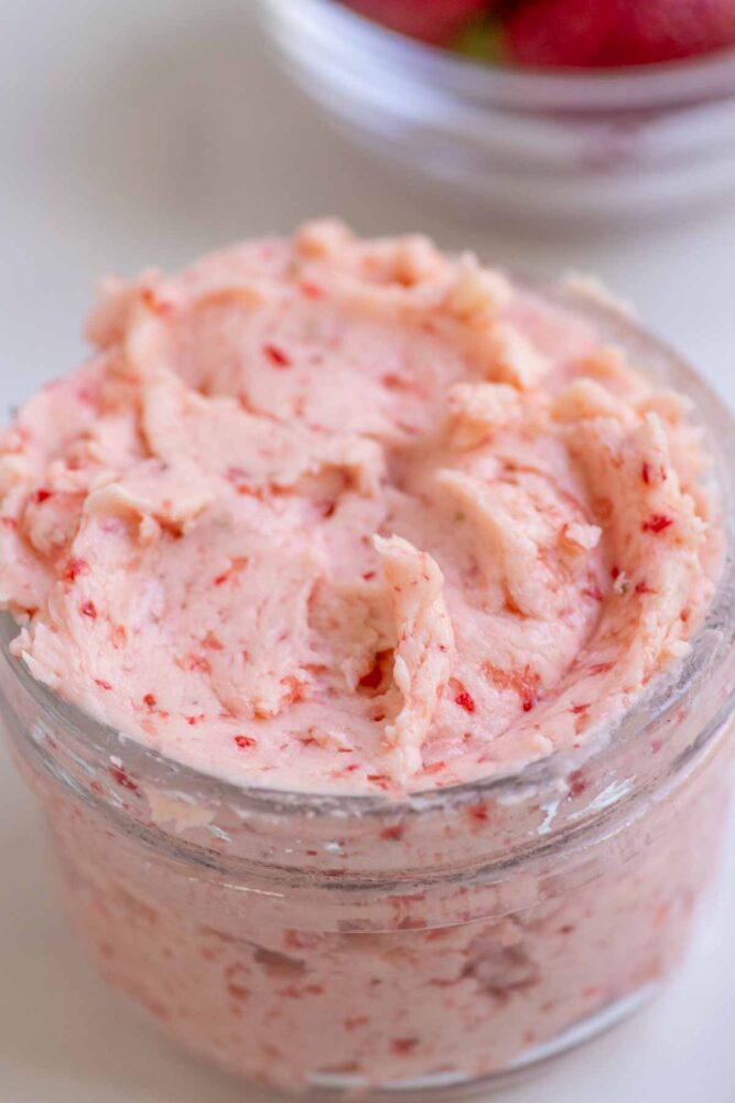 Close up picture of strawberry butter in a glass jar.