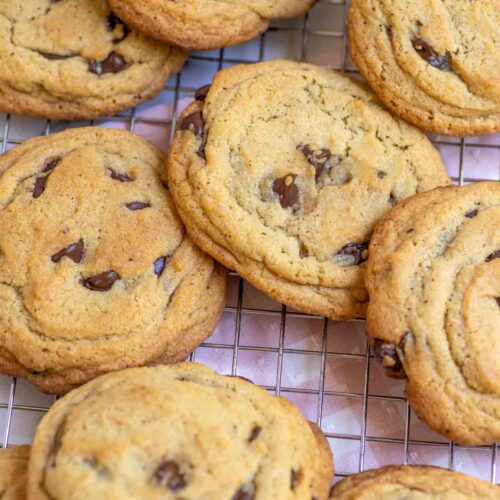 Thick and chewy browned butter sourdough chocolate chip cookies on a cooling rack.