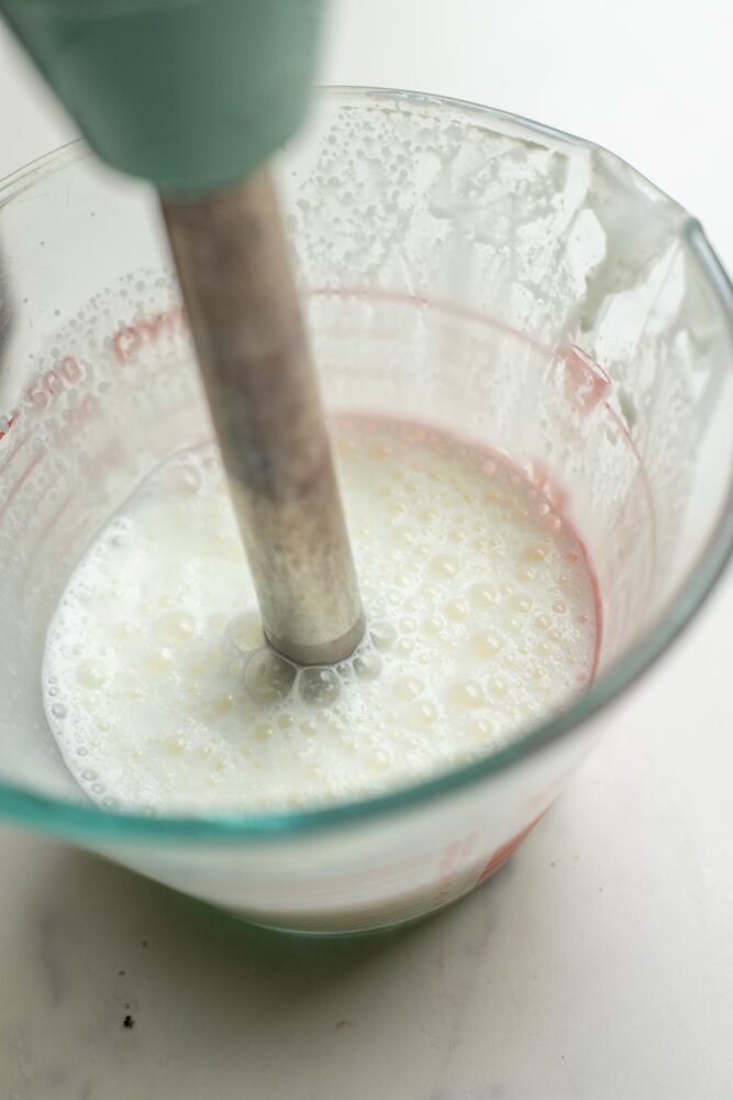 Frothing milk with an immersion blender.