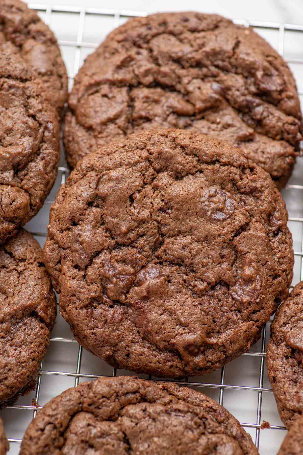 Sourdough double chocolate cookies piled on a cooling rack.