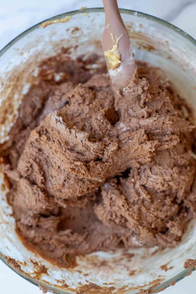 Dry ingredients added to wet ingredients in a glass bowl.