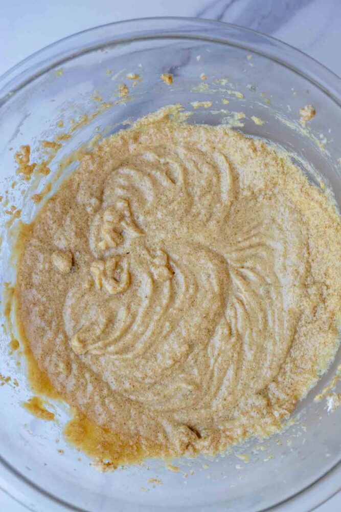 Eggs, sourdough starter, and vanilla added to creamed sugar and butter in a bowl.