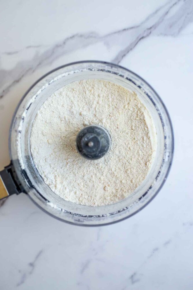 butter, flour, sugar, baking powder mixed together in a food processor.