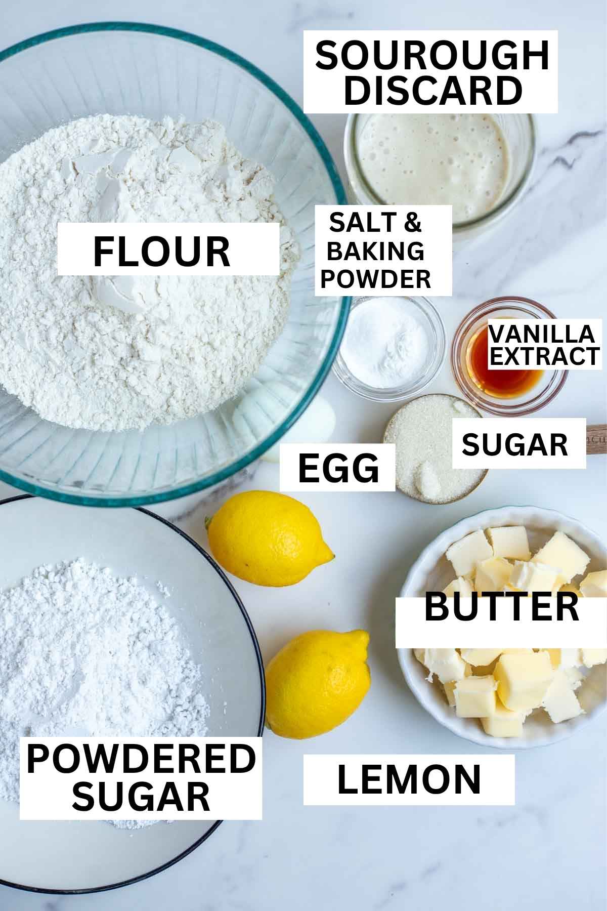 Flour, butter, sourdough discard, lemons, and other ingredients on a countertop.