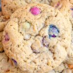 Up close picture of sourdough M&M Cookies stacked on a blue plate.