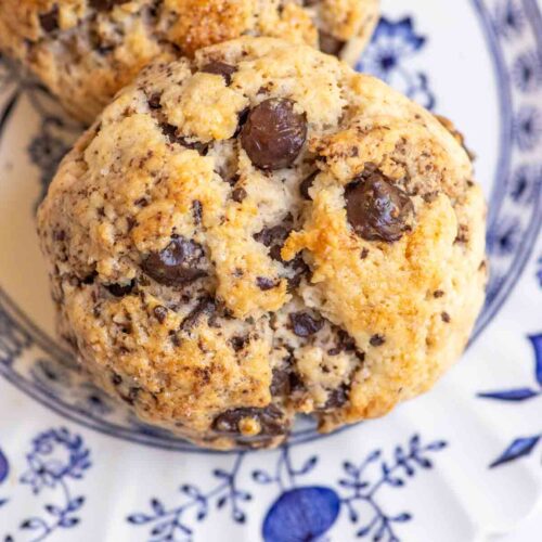 Close up of two sourdough chocolate chip scones make with discard on a white plate.