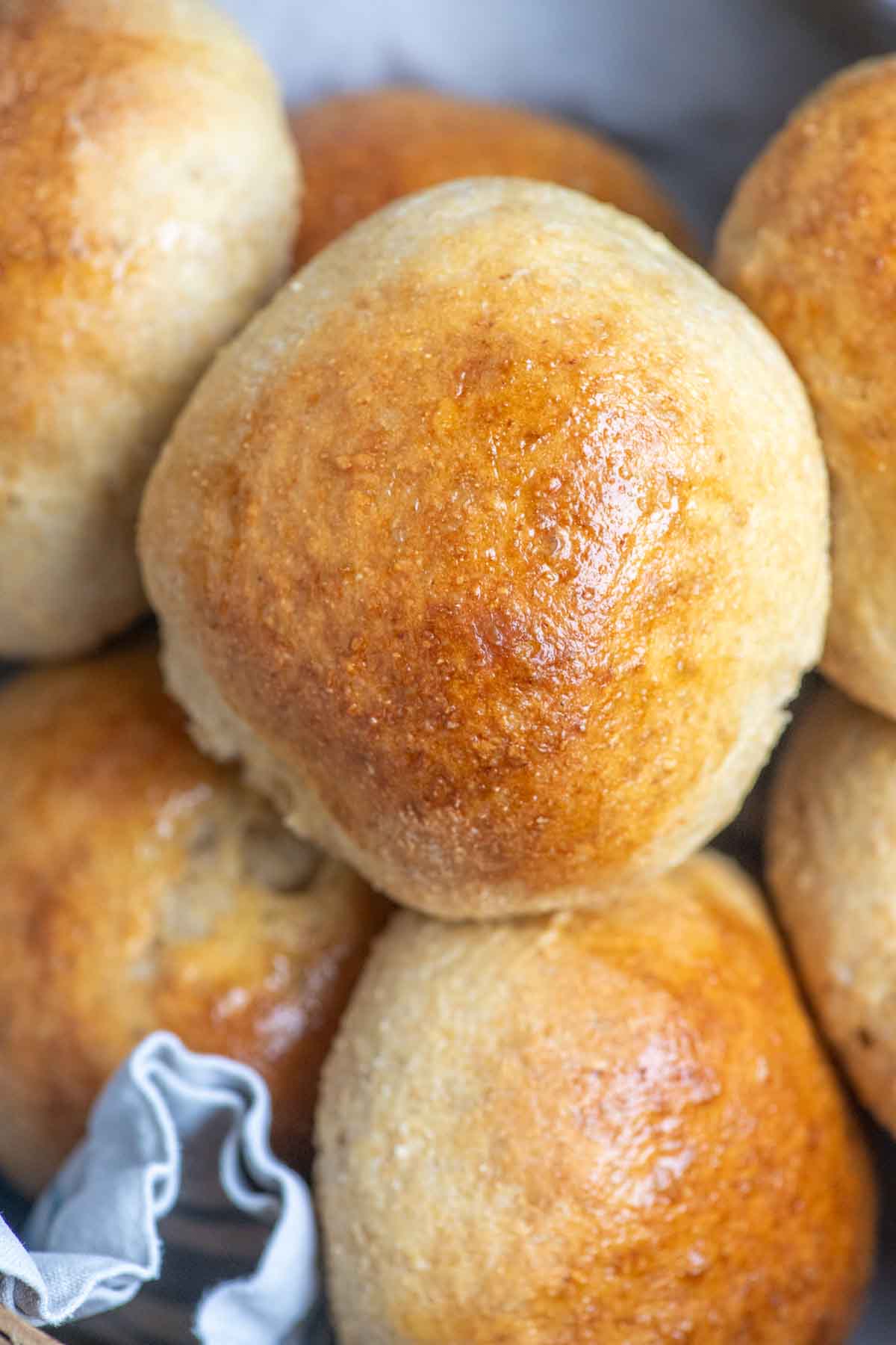 Close up picture of whole wheat burger buns stacked in a basket.
