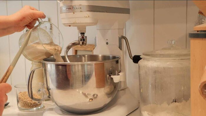 Adding liquid ingredients to stand mixer.