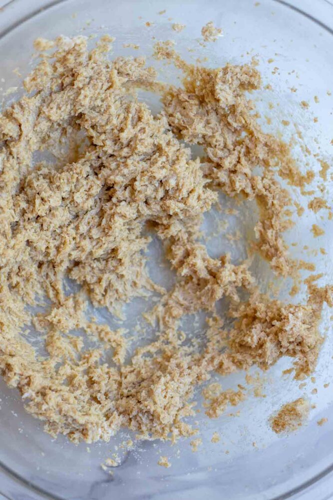 Butter and sugar creamed together in a glass bowl.
