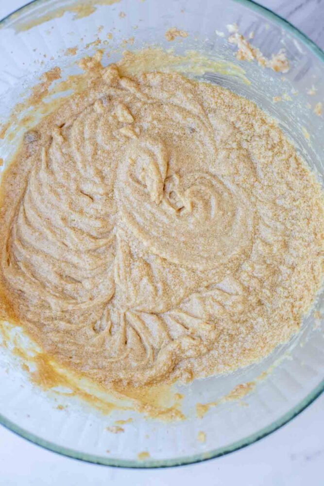 Sourdough starter, eggs, and vanilla added creamed butter and sugar in a glass bowl.