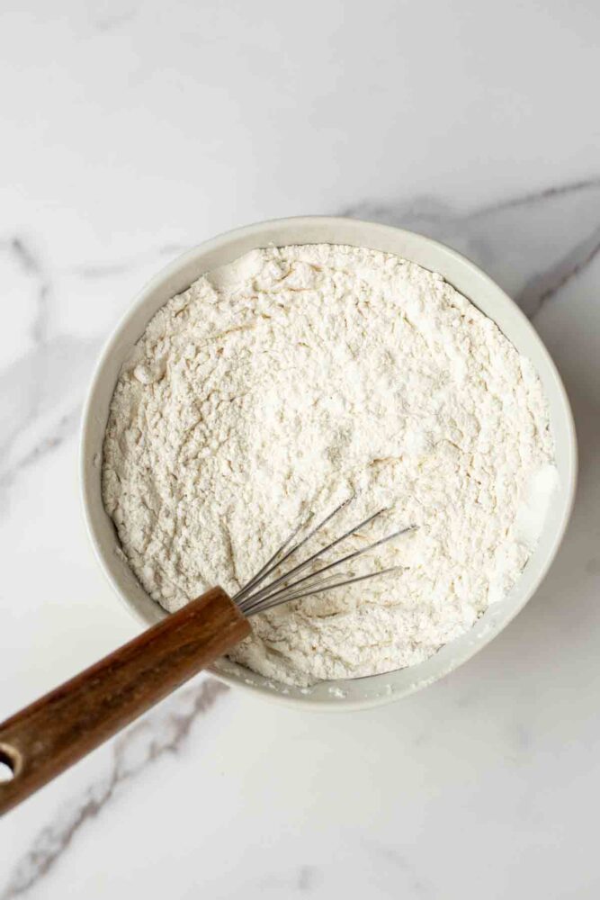 Dry ingredients mixed together in a bowl with a whisk.